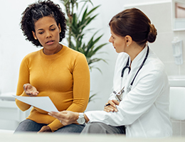 A doctor and patient review a document together.
